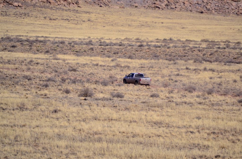 A pickup drives through Twin Buttes Ranch as part of the cattle ranching operation