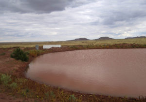 Shallow dirt tank - water reservoir on Twin Buttes Ranch Arizona