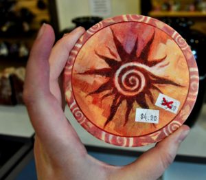 Decorative rock coaster with spiral sun and southwestern theme colors